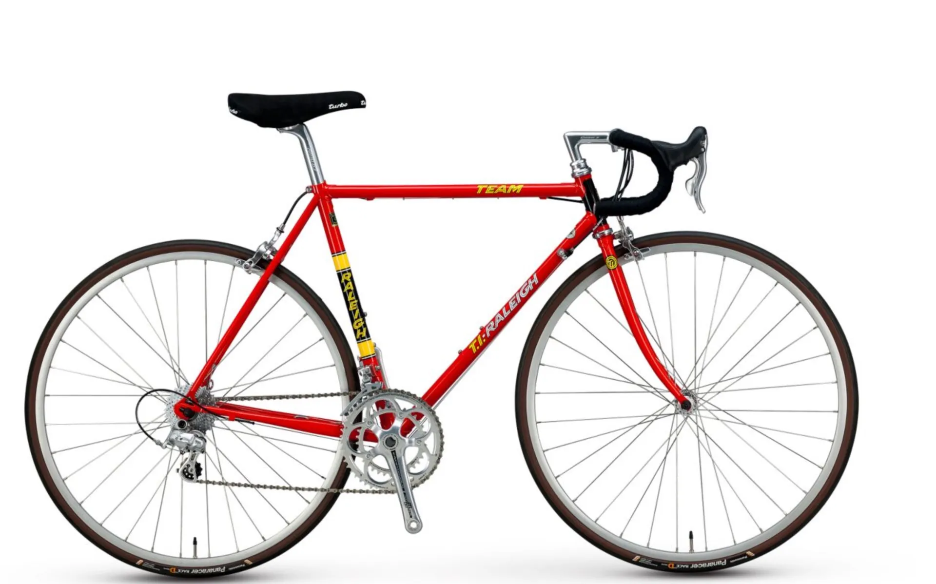 A red steel road bike with drop handlebars and a black saddle